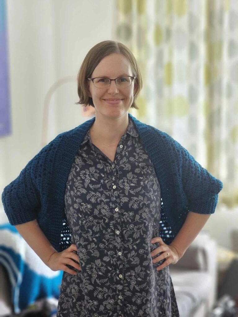 Woman wearing blue crocheted shrug