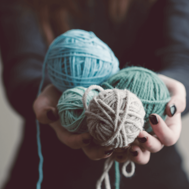 Colorful yarn balls in hands