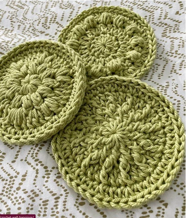 Three green crochet coasters