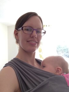 Smiling mom babywearing