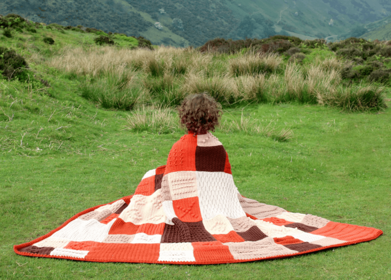 Person wrapped in patchwork blanket