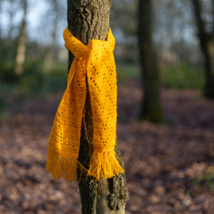 Yellow crocheted scarf on tree