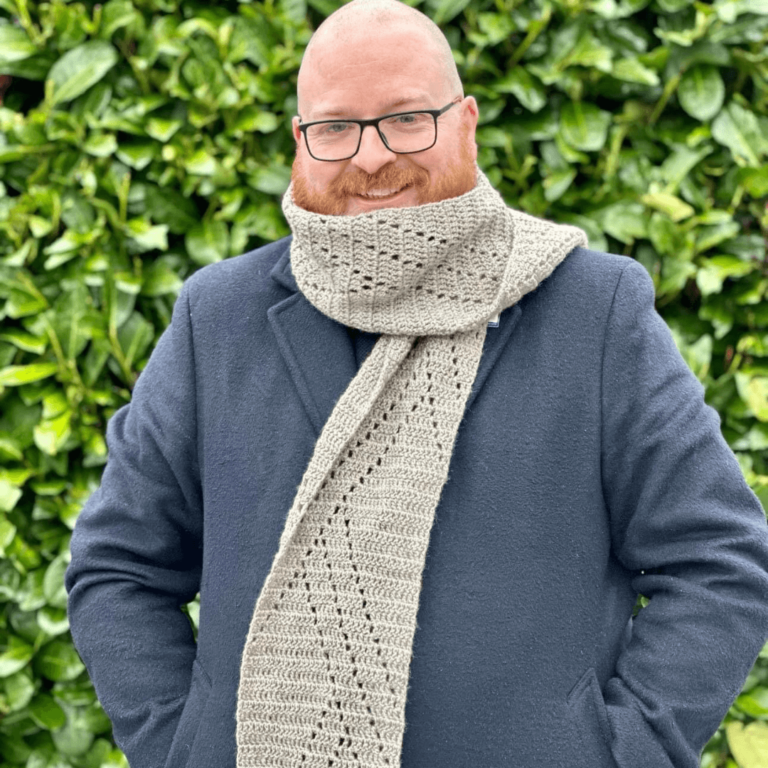 Smiling man grey crochet scarf